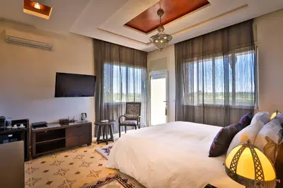 a bedroom with a bed and a flat screen tv at Palais Amador in Marrakech