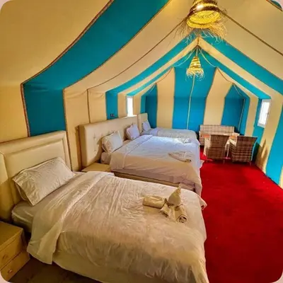 two beds in a room with a tent at Luxury Desert Central Camp in Merzouga