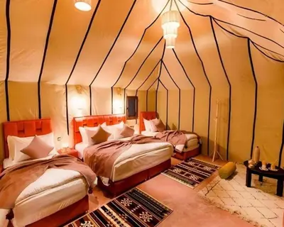 a bedroom with two beds in a tent at spirit desert camp in Merzouga