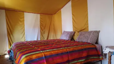 a bedroom with a bed in a tent at Camp Sahara Dunes in Mhamid