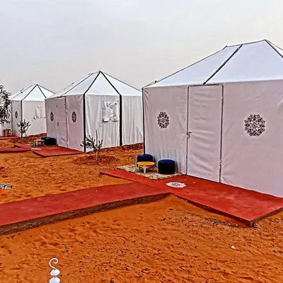 a row of white tents in the desert at Safari luxury desert camp in Merzouga