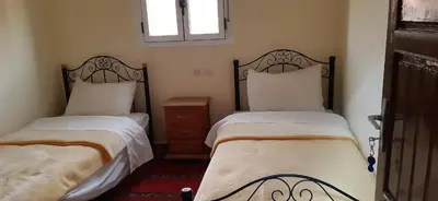 a bedroom with two beds and a window at Auberge l' avenir in Imilchil