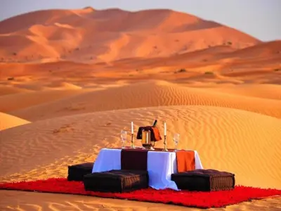 a table in the middle of a desert at lecherif luxury Camps in Merzouga