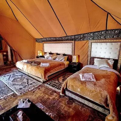 a bedroom with two beds in a tent at Sahara Luxury Glamping in Merzouga