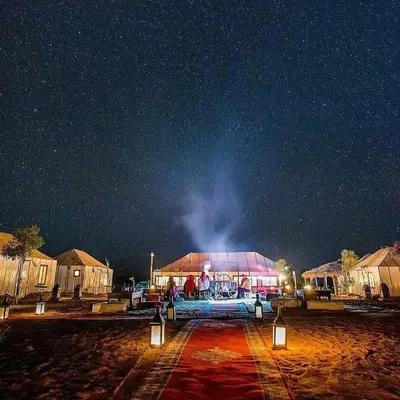 a large building with people on it under a night sky at Sahara Luxury Glamping in Merzouga