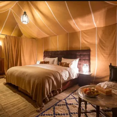 a bedroom with a bed in a tent at Overnight Luxury Camp in Merzouga
