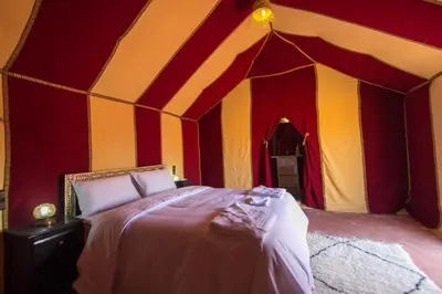 a room with a bed in a tent at Camel Experience Camp in Merzouga