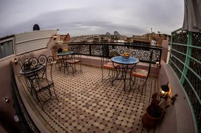 a balcony with tables and chairs on a balcony at Dar Elhaja Rahma in Fès