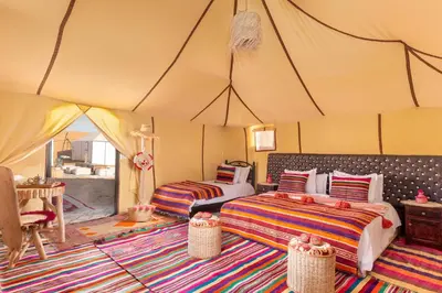 a bedroom with two beds in a tent at Aisha Luxury Camp in Merzouga