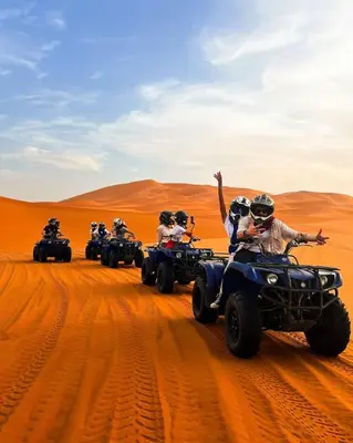 a group of people riding atvs in the desert at Merzouga Exclusive Camp in Merzouga