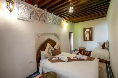 a room with two beds in a room with a window at Dar Authentic Fes - familly hosting in Fès