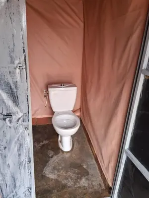 a small bathroom with a toilet in a tent at Unforgettable Nights in Merzouga in Merzouga