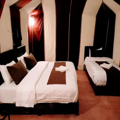 a hotel room with two beds in a room at Merzouga Berber Camps in Merzouga