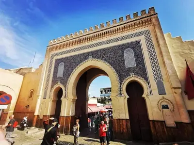 a building with an arch with people standing around it at Appartement Centre Ville - ATLAS in Fès