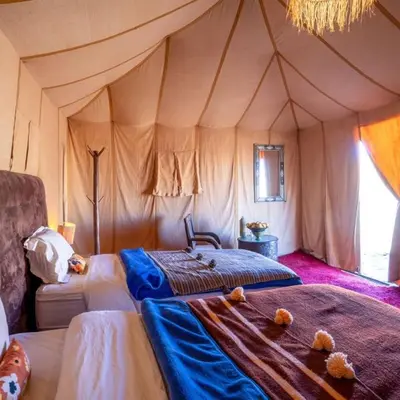 a bedroom with two beds in a tent at Sahara Elegance Camp in Merzouga