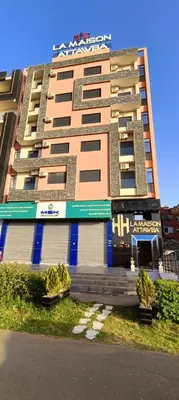 a tall apartment building withcriptions on the side of it at APPART-HOTEL La MAISON ATTAWBA 2 in Beni Mellal