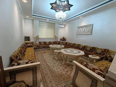 a living room with a couch and a chandelier at Appartement a Meknès-Hamria in Meknès