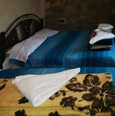 a bed with a pillow and a blanket on it at Taghia Accommodation in Taghia
