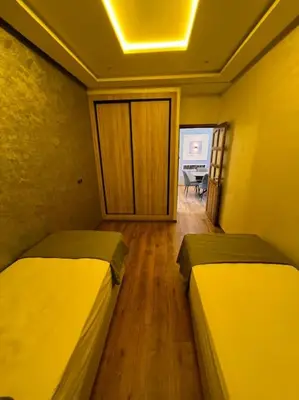 a room with two beds and a room with a table at Appartement fes sami haut standing in Fès