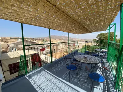 a balcony with a table and chairs and a view at Dar Zerbtana Chambre chaoune in Fès