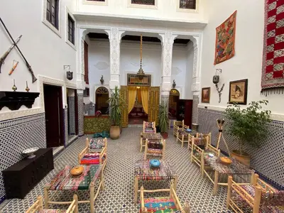 a room with tables and chairs in a building at Dar Zarbtana Chambre Essaouira in Fès