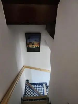 a stairway with a picture of a palm tree on the wall at Dar Zarbtana Chambre Hiba in Fès