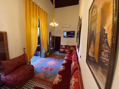 a living room with a couch and a mirror at Dar Zarbtana Chambre Hiba in Fès