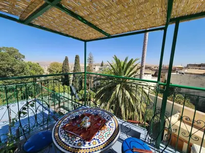 a table with a plate of food on a balcony at Dar Zarbtana Chambre RADIA in Fès