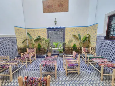 a room with chairs and tables in a room at Dar Zarbtana Chambre RADIA in Fès
