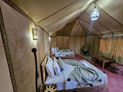 a room with two beds in a tent at Merzouga Dunes Luxury Glamping Camp in Merzouga