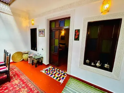 a living room with colorful glass doors and a floor at Blue Star Hostel in Fès