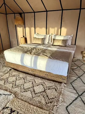 a bedroom with a large bed in a tent at Anir Luxury Camp - Gites et Tentes de Luxe in Merzouga