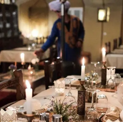 a man standing in front of a table with candles at Merzouga Sardegna Luxury Camp in Merzouga