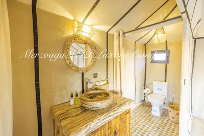 a bathroom with a sink and a toilet in a tent at Merzouga VIP Luxury Camp in Merzouga
