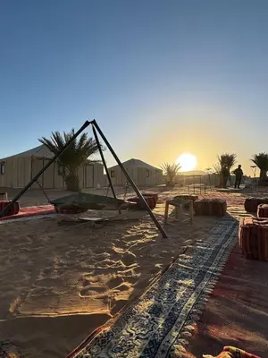 a large object on the beach with the sunset in the background at erg sahara merzouga in Ouzina