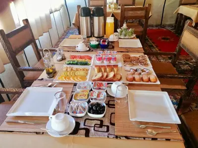 a table with several trays of different types of pastries at Expérience Inoubliable dans une Tente de Luxe en plein Désert de Merzouga ! in Merzouga