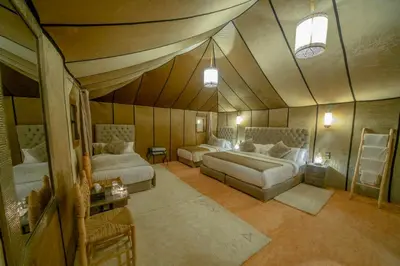 a bedroom with two beds in a room with a ceiling at Expérience Inoubliable dans une Tente de Luxe en plein Désert de Merzouga ! in Merzouga