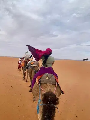a group of people riding horses in the desert at Luxury Merzouga Camp in Merzouga