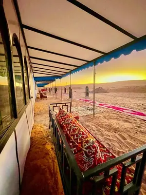 a row of benches on a beach with a mural at Desert Nights Camp in Merzouga