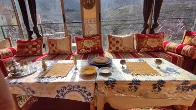 a table with plates of food on it in front of a window at GITE DETAPE DAR AGSWAL DOUAR WANSKRA OUED IMNANE ASNI MARRAKECh in Tacheddirt