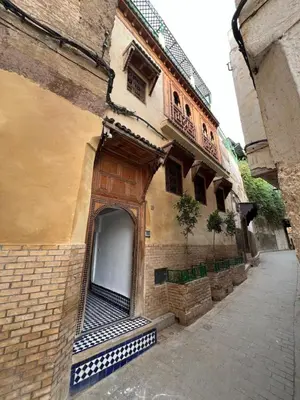 an old building with an open door on a street at Dar Moulin in Fès