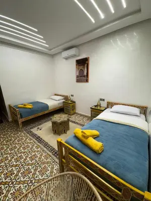 a room with two beds and two chairs in it at Appartement Dar LALA 2 in Fès