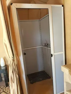 a shower with a glass door in a bathroom at Golden Sahara camp in Merzouga