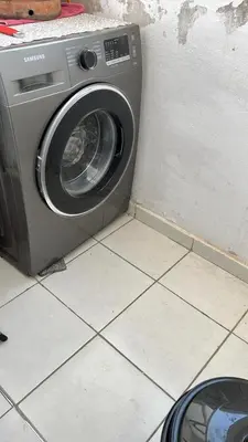 a washing machine sitting on a tiled floor next to a wall at واد فاس طريق مكناس تجزئة البركه قرب طريق الجامعه المتوسطه لاغوميد in Fès