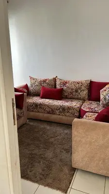 a couch with red pillows in a living room at واد فاس in Fès
