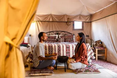 a man and woman sitting in a tent at Luxury beldi camp in Merzouga