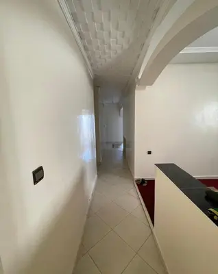 a long hallway with a white wall and a room at Casa de playa in Oulad Akkou