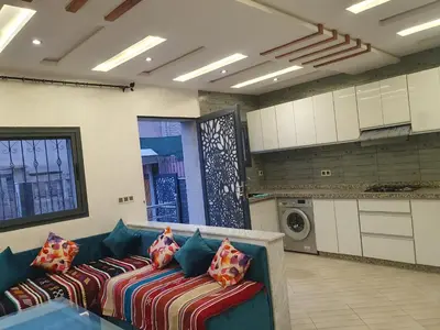 a living room with a blue couch with pillows at Dar diafa in Imouzzer Kandar
