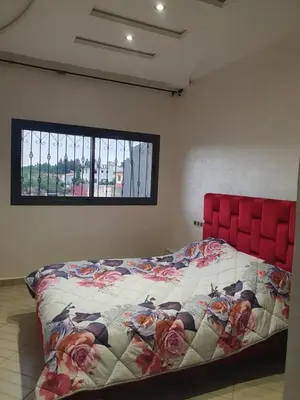 a bed with a red head board in a room at Dar diafa in Imouzzer Kandar