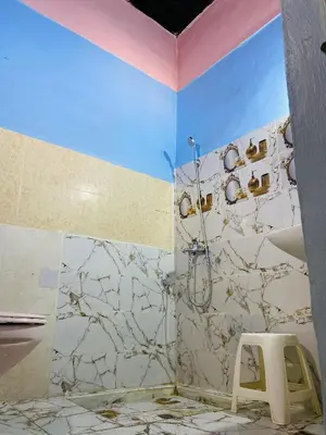a bathroom with a shower and a stool at Fes Antique Hostel in Fès